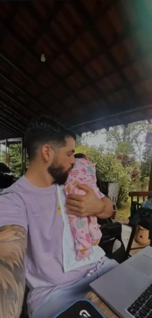 Pietro trabalhando com a filha no colo